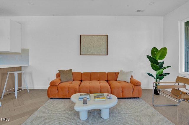 living area with baseboards and visible vents