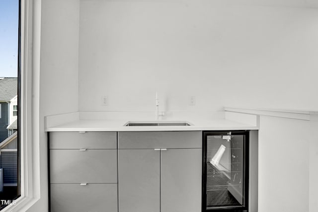 bar featuring wine cooler and a sink