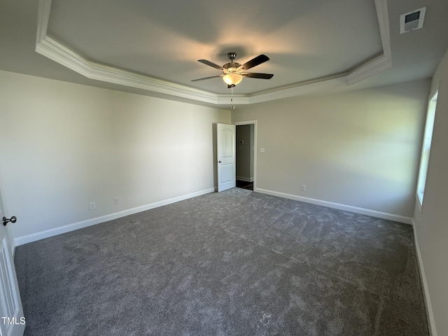 empty room with visible vents, ceiling fan, a raised ceiling, and baseboards