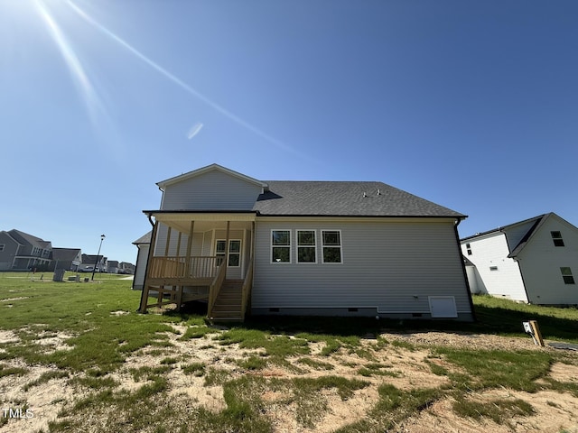 back of house featuring a lawn and crawl space