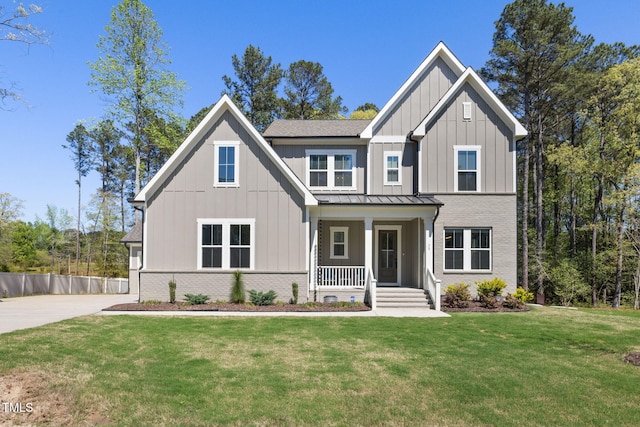 50 Gadwall Ct, Zebulon, NC 27597 - modern farmhouse style home with board and batten siding, a standing seam roof, a porch, and a front lawn