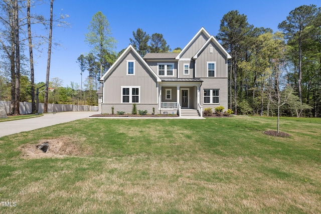 50 Gadwall Ct, Zebulon, NC 27597 - view of front facade with fence, covered porch, a standing seam roof, board and batten siding, and metal roof
