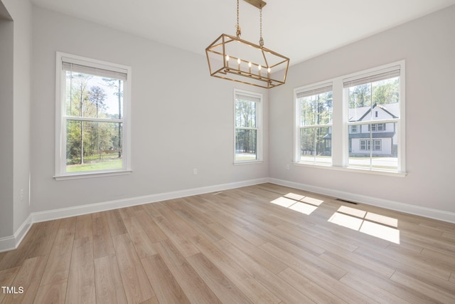 50 Gadwall Ct, Zebulon, NC 27597 - unfurnished dining area with an inviting chandelier, light wood-style floors, plenty of natural light, and baseboards