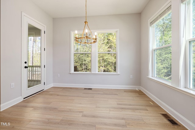 50 Gadwall Ct, Zebulon, NC 27597 - unfurnished dining area featuring baseboards, light wood-style flooring, a chandelier, and visible vents