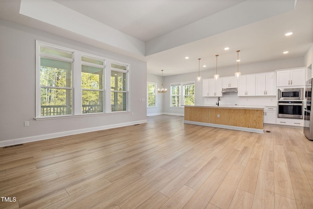50 Gadwall Ct, Zebulon, NC 27597 - unfurnished living room with visible vents, recessed lighting, light wood-style flooring, and a chandelier