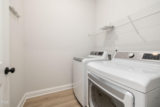 50 Gadwall Ct, Zebulon, NC 27597 - washroom with baseboards, laundry area, washing machine and dryer, and light wood-style flooring
