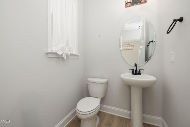 50 Gadwall Ct, Zebulon, NC 27597 - half bath featuring toilet, baseboards, a sink, and wood finished floors