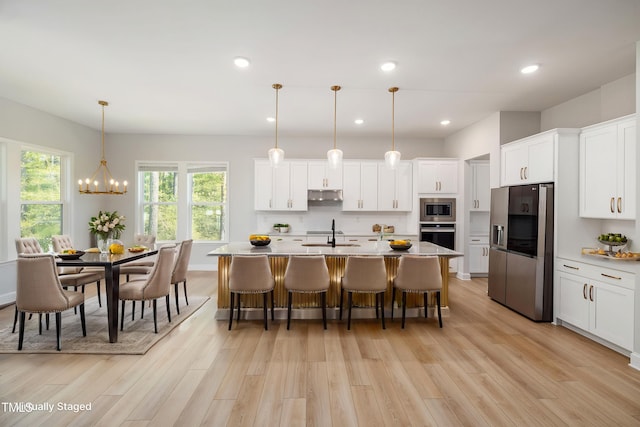 50 Gadwall Ct, Zebulon, NC 27597 - kitchen with white cabinetry, under cabinet range hood, a sink, light wood finished floors, and appliances with stainless steel finishes