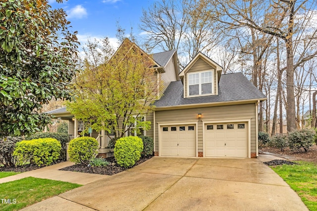 view of front facade with concrete driveway, a garage, and a shingled roof