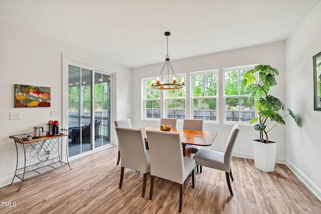 dining area featuring a chandelier, wood finished floors, and baseboards