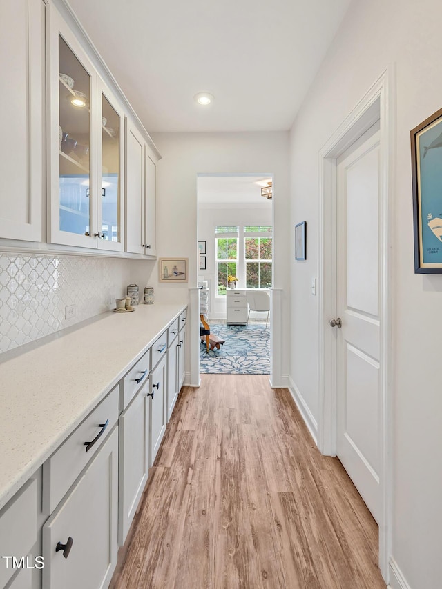 interior space with tasteful backsplash, light wood-style floors, baseboards, and recessed lighting