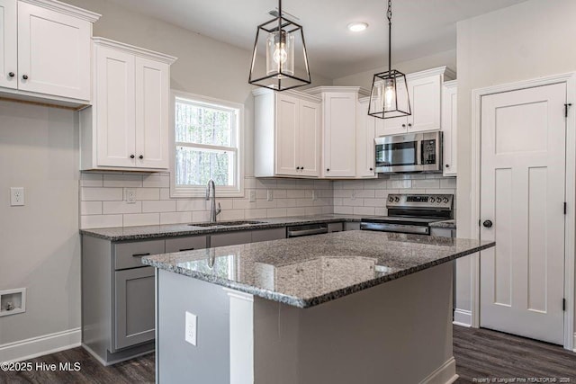190 Love Grove Church Rd, West End, NC 27376 - kitchen with dark stone counters, stainless steel appliances, tasteful backsplash, dark wood finished floors, and a sink