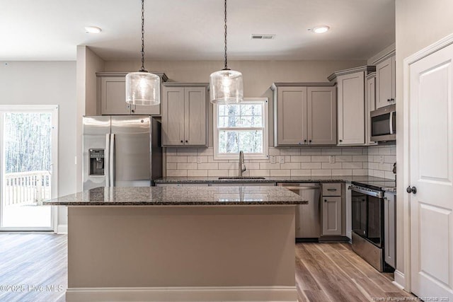 190 Love Grove Church Rd, West End, NC 27376 - kitchen with light wood-type flooring, gray cabinets, a kitchen island, a sink, and appliances with stainless steel finishes