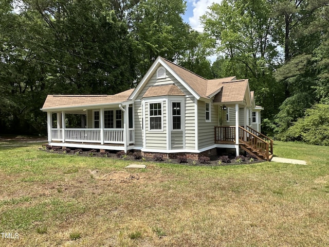 back of house with roof with shingles, covered porch, and a yard