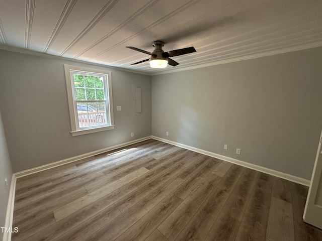 empty room featuring baseboards, ornamental molding, ceiling fan, and wood finished floors