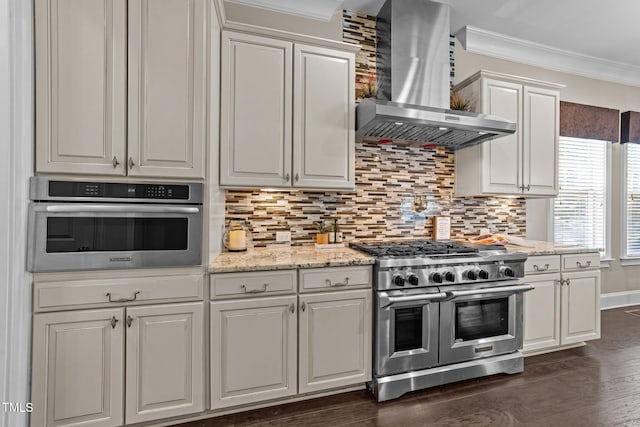kitchen featuring ornamental molding, wall chimney exhaust hood, appliances with stainless steel finishes, and tasteful backsplash