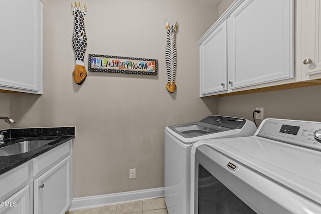 clothes washing area featuring cabinet space, a sink, baseboards, light tile patterned floors, and separate washer and dryer