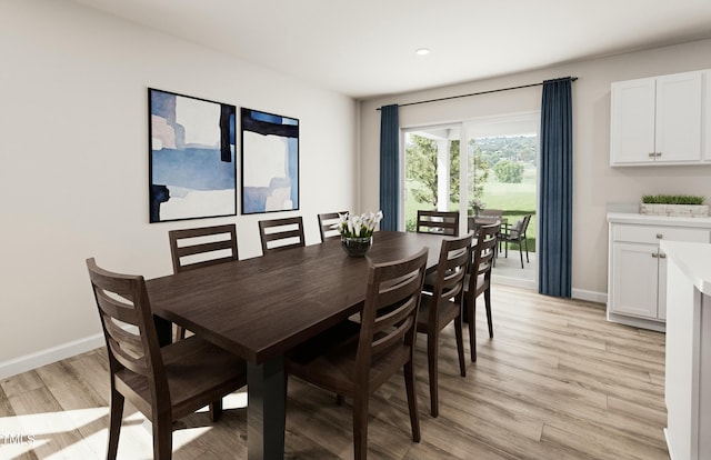 dining area featuring baseboards and light wood finished floors