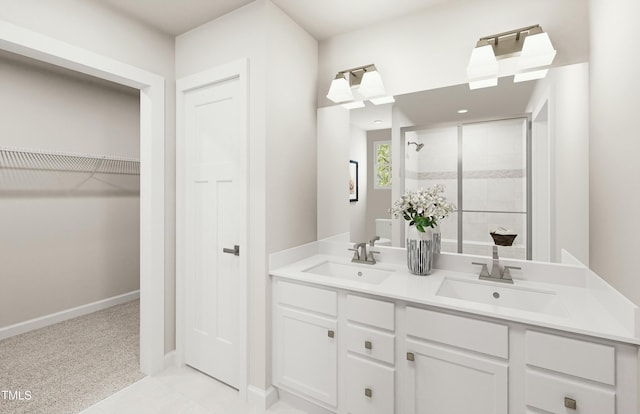 bathroom with a sink, a walk in closet, baseboards, and a shower stall