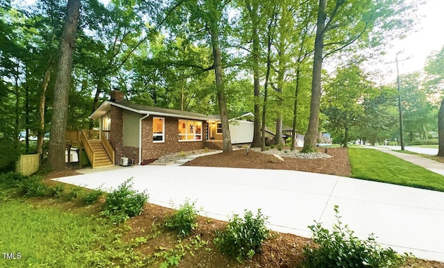 1124 Hardimont Rd, Raleigh, NC 27609 - view of front facade featuring stairway, brick siding, a chimney, and a deck