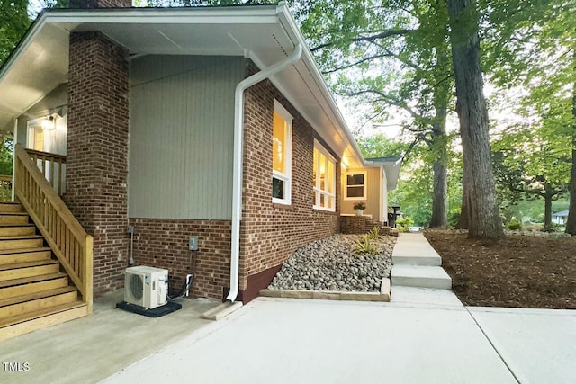 1124 Hardimont Rd, Raleigh, NC 27609 - view of property exterior featuring brick siding, ac unit, a patio, and stairs