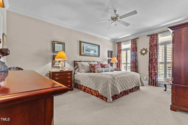 carpeted bedroom with ornamental molding and a ceiling fan