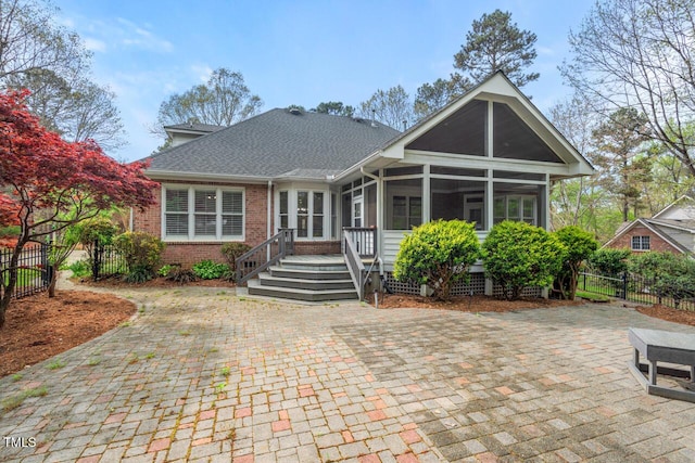 5900 Orchid Valley Rd, Raleigh, NC 27613 - view of front of property with a sunroom, brick siding, roof with shingles, and a patio