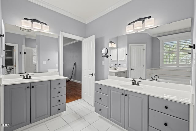 5900 Orchid Valley Rd, Raleigh, NC 27613 - full bath with two vanities, crown molding, tile patterned floors, a tub to relax in, and baseboards