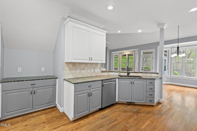5900 Orchid Valley Rd, Raleigh, NC 27613 - kitchen featuring stainless steel dishwasher, a sink, lofted ceiling, light wood-type flooring, and a peninsula