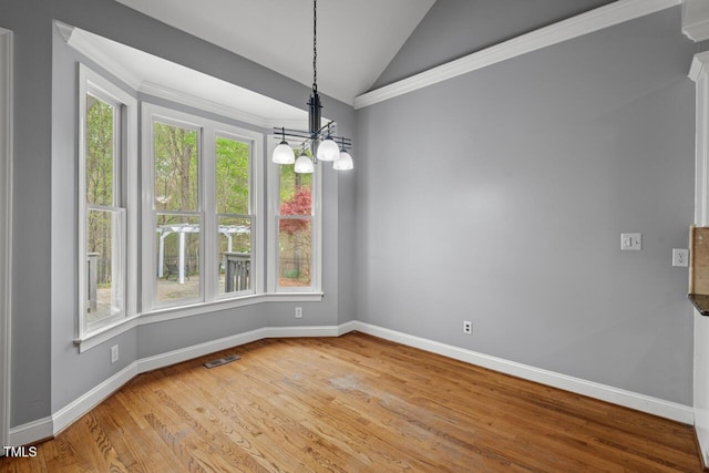 5900 Orchid Valley Rd, Raleigh, NC 27613 - empty room featuring healthy amount of natural light, lofted ceiling, a chandelier, baseboards, and light wood-style flooring