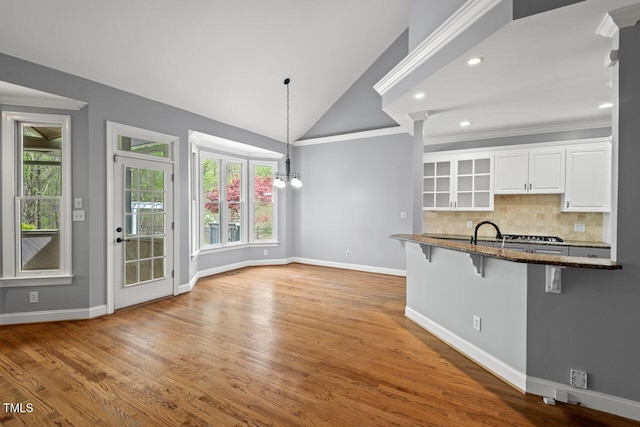 5900 Orchid Valley Rd, Raleigh, NC 27613 - kitchen with a kitchen bar, dark stone counters, healthy amount of natural light, white cabinets, and lofted ceiling