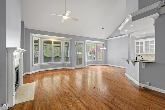 5900 Orchid Valley Rd, Raleigh, NC 27613 - unfurnished living room with a ceiling fan, high vaulted ceiling, baseboards, a fireplace, and wood finished floors