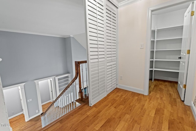 5900 Orchid Valley Rd, Raleigh, NC 27613 - corridor with an upstairs landing, ornamental molding, baseboards, and light wood-style flooring