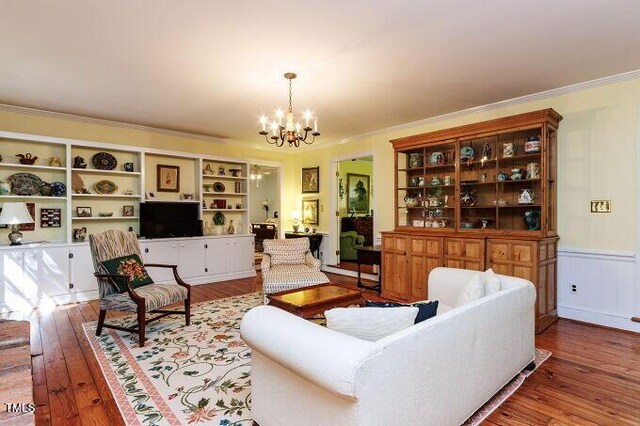 3005 Woodgreen Dr, Raleigh, NC 27607 - living area featuring crown molding, a chandelier, wood finished floors, and wainscoting