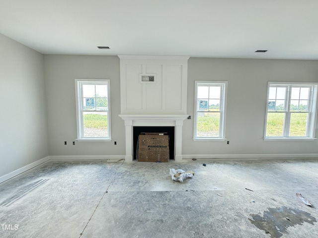 unfurnished living room featuring a fireplace and baseboards
