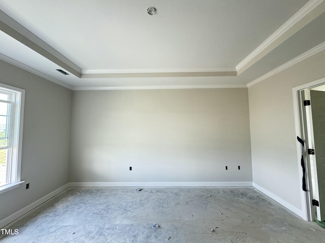 empty room featuring ornamental molding, plenty of natural light, concrete floors, baseboards, and a tray ceiling