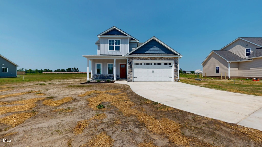 1365 Stoney Creek Church Rd, Goldsboro, NC 27534 - craftsman inspired home with board and batten siding, stone siding, driveway, a porch, and an attached garage