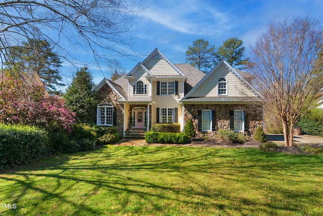 view of front of home featuring a front lawn and stone siding