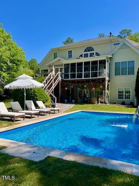 pool featuring stairs, a sunroom, and a patio area