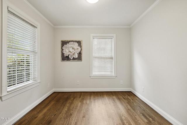 spare room featuring dark wood-style floors, baseboards, and ornamental molding