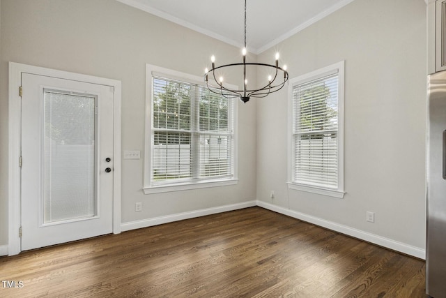 unfurnished dining area with wood finished floors, an inviting chandelier, crown molding, and a healthy amount of sunlight