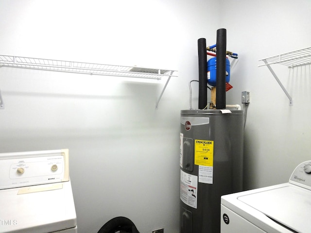 washroom with water heater, washing machine and dryer, and laundry area