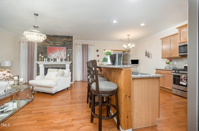 1030 Thoughtful Spot Ln, Durham, NC 27703 - kitchen with a chandelier, stainless steel appliances, crown molding, a breakfast bar area, and light brown cabinets