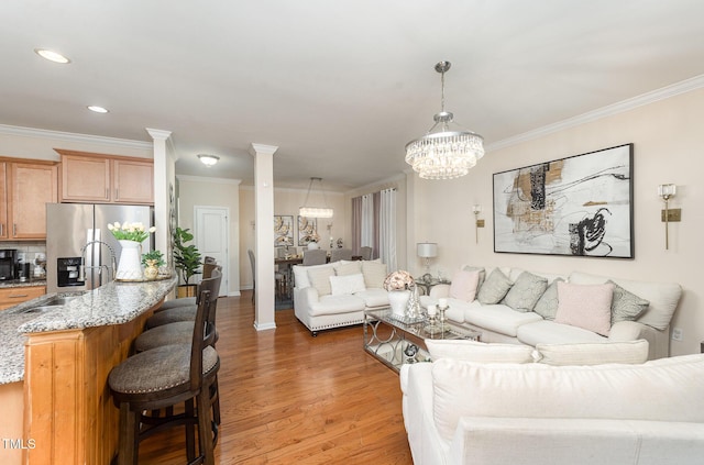 1030 Thoughtful Spot Ln, Durham, NC 27703 - living room featuring a chandelier, crown molding, light wood-type flooring, recessed lighting, and ornate columns