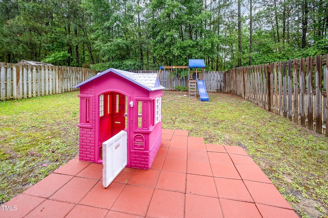 1030 Thoughtful Spot Ln, Durham, NC 27703 - view of patio / terrace with a playground, a fenced backyard, and view of wooded area