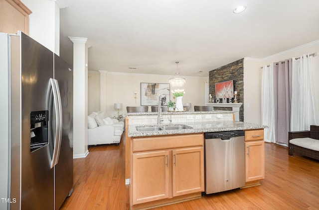 1030 Thoughtful Spot Ln, Durham, NC 27703 - kitchen with stainless steel appliances, a sink, light wood-type flooring, a kitchen island with sink, and ornamental molding