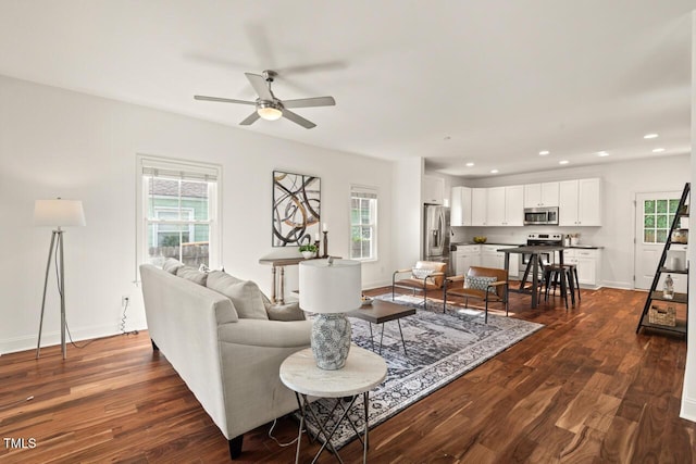 living room with healthy amount of natural light, ceiling fan, dark wood finished floors, recessed lighting, and baseboards