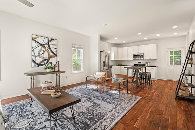 living area with plenty of natural light, dark wood-style flooring, baseboards, and recessed lighting