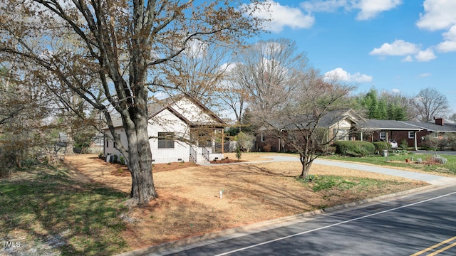view of front facade with crawl space, uncovered parking, and a front lawn