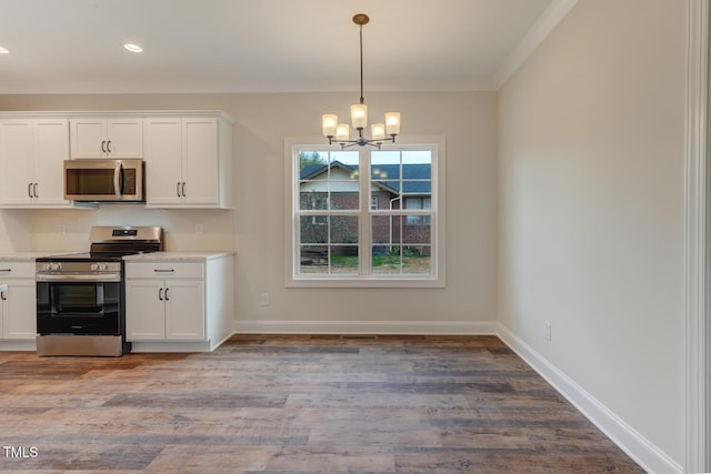 kitchen featuring light countertops, light wood-style floors, white cabinets, a notable chandelier, and appliances with stainless steel finishes